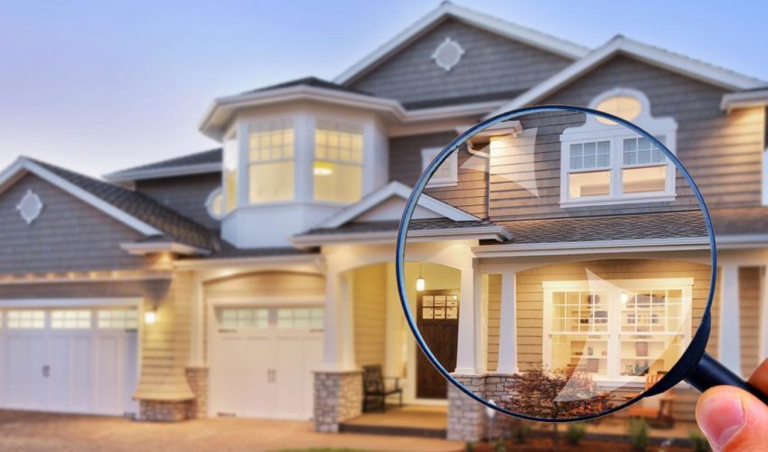 A large magnifying glass examining a two-story house with a garage, highlighting details of the exterior and landscaping.